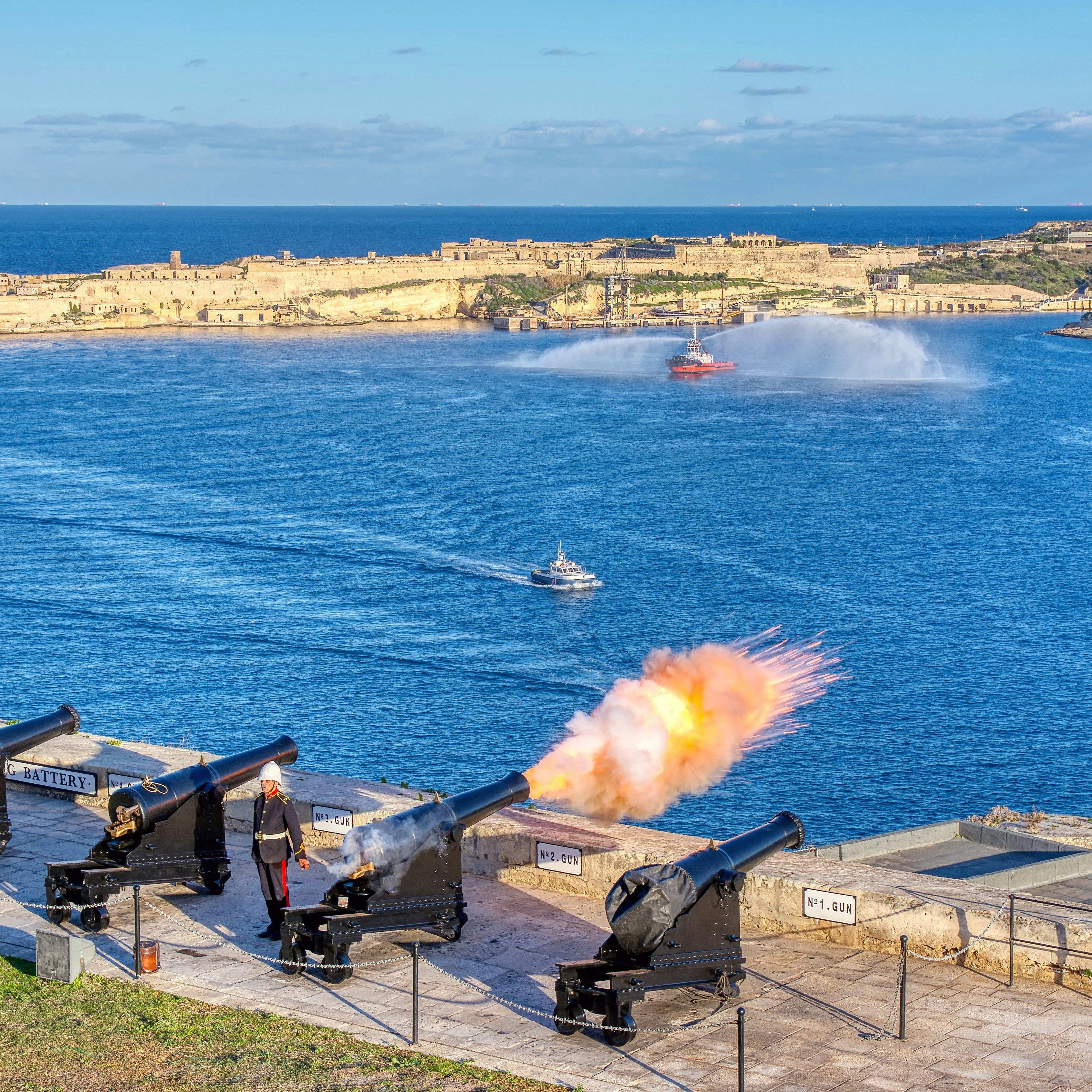 Valletta, Malta - January 9, 2020: Shot from cannon at noon in Saluting Battery at Upper Barrakka Gardens, with Birgu on the background, Valletta, Malta.